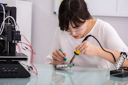 Female Engineer Or Tech Repairs Electronic Device In Hardware Repair Shop