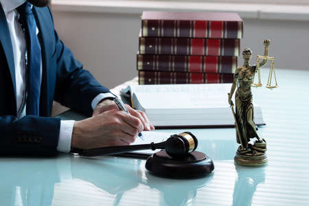 Mallet And Sounding Block With Statue Of Justice In Front Of Judge At Court