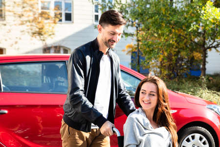 Close-up Of Man With Her Wife Sitting On Wheelchair Moving With Car
