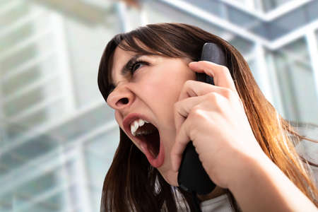 Close-up Of Frustrated Businesswoman Yelling On Phoneの写真素材