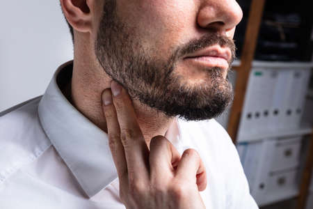 Close-up Of Young Man Touching His Neck To Eliminate High Blood Pressure