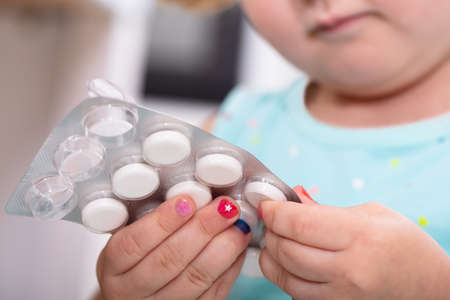 Close-up Of Girls Hand Removing Tablet From Blister Packの写真素材
