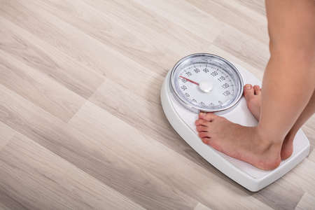 Low Section Of Woman Foot On Weighting Scale At Homeの写真素材
