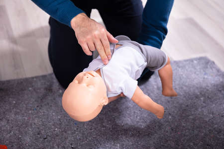 Specialist Giving Baby CPR Dummy First Aid Training To His Colleaguesの写真素材