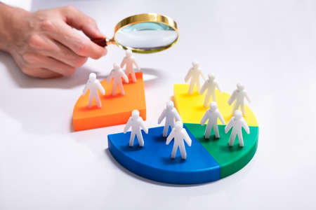 Businesspeople Analyzing Market Segment Using Magnifying Glassの写真素材