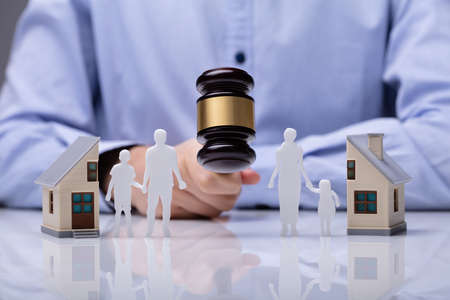 Close-up Of Mallet Showing Separation Of Family And House On Reflective Deskの写真素材