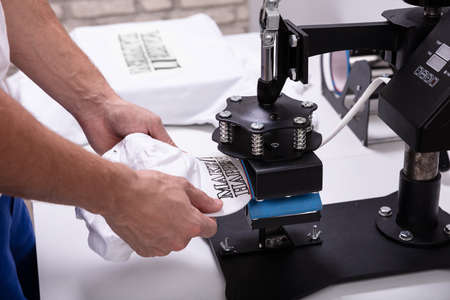 Man printing on baseball cap in workshopの写真素材