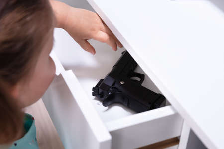 Close-up Girl Found Pistol In Drawer At Homeの写真素材