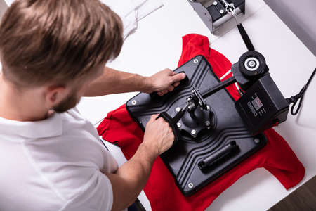 Man printing on t shirt in workshopの写真素材
