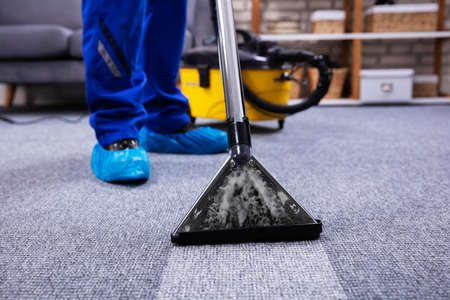 Human Cleaning Carpet In The Living Room Using Vacuum Cleaner At Homeの写真素材
