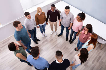 Group Of Multi-ethnic People Standing In Circle Holding Each Other Hands