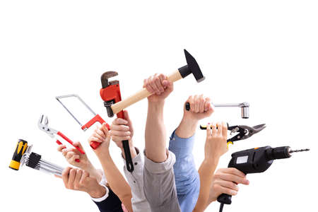 Close-up Of People's Hand Holding Carpentry Tools Against White Background