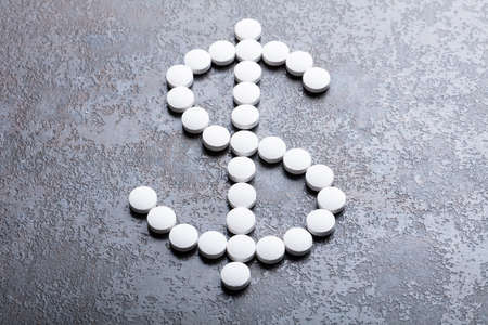 An Elevated View Of White Round Pills In The Shape Of A Dollar Signの写真素材