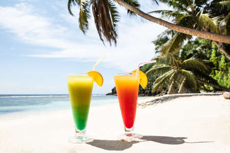 Close-up Of Colorful Cocktail Glasses On The Sandy Beachの写真素材