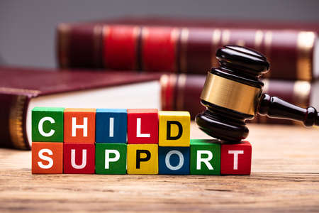 Child Support Colorful Block With Bible And Hammer Over Wooden Desk In Courtroom