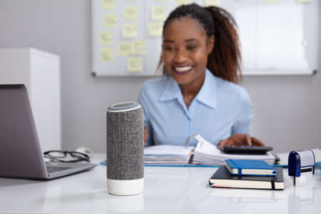 Close-up Of Voice Assistant In Front Of Businesswomanの写真素材