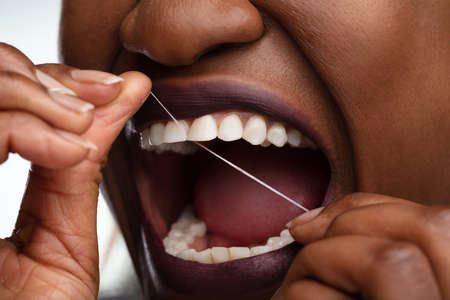 Close-up Of A Woman's Hand Flossing Her Teethの写真素材