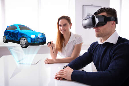 Man Wearing VR Headset Looking At Car Model With Female Agent Holding Remote