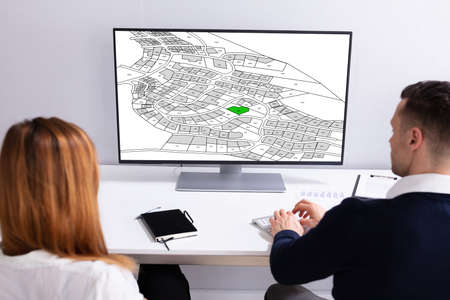 Close-up Of A Businesspeople Analyzing Cadastre Map On Computer In The Officeの写真素材