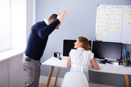 Angry Businessman Shouting At Female Executive In Office
