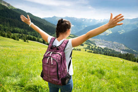 Woman With Backpack Enjoying Panoramic Mountain Viewの写真素材