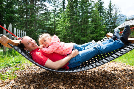 Father And Little Girl Relaxing In Hammock In Mountainsの写真素材