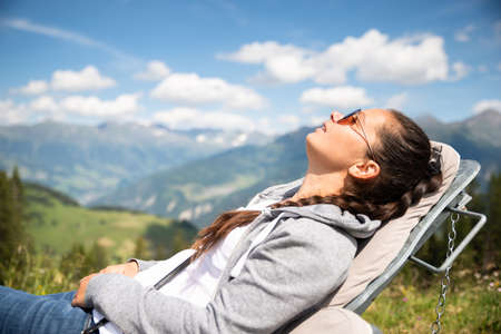 Woman Relaxing In Sun Lounger In Mountainsの写真素材