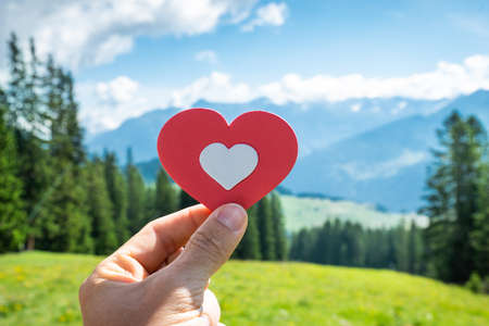 Person Holding Heart With Scenic Panorama Mountain View In Backgroundの写真素材