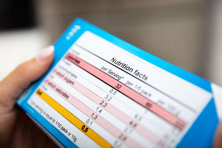 Close-up Of Woman Reading Nutrition Facts On Boxの写真素材