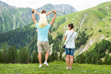 Rear View Of Family Looking At Panoramic Mountain Viewの写真素材