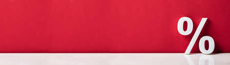 White Percent Sign In Front Of Red Wall
