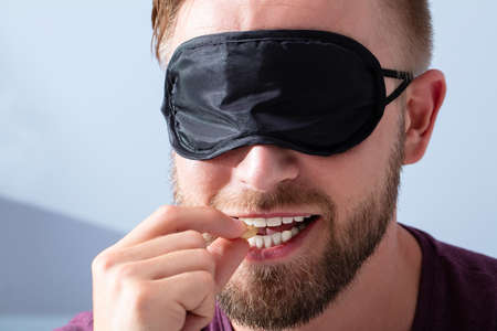 Portrait Of Blindfolded Young Man Tasting Food