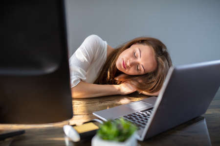 Tired Young Businesswoman Working At Office With Computer And Laptop Over Desk In Office