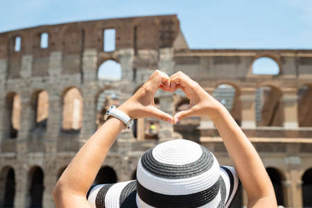 Woman Making Heart Shape In Front Of Colosseum, Italyの写真素材