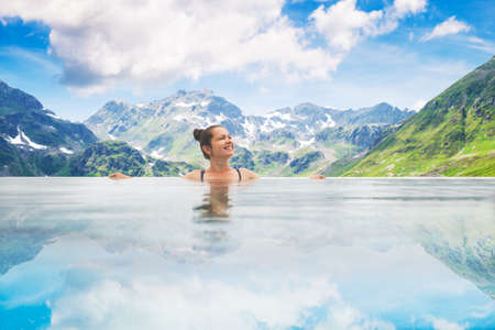 Photo Of Woman In Infinity Pool In Mountainsの写真素材