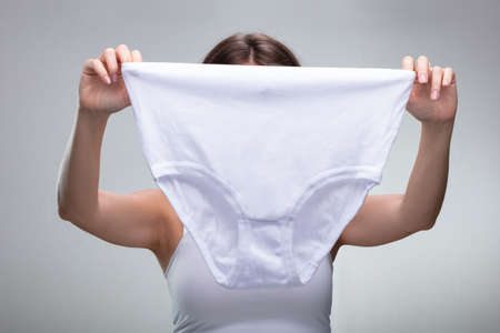 Close-up Of A Woman Holding White Underwearの写真素材