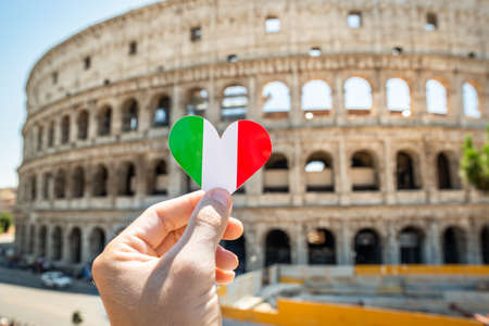 Person Holding Heart Shaped Italian Flag In Front Of Colosseum, Italyの写真素材