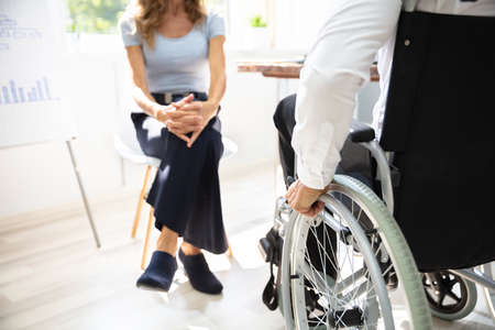 Rear View Of Disabled Businessman In Meeting At Workplaceの写真素材