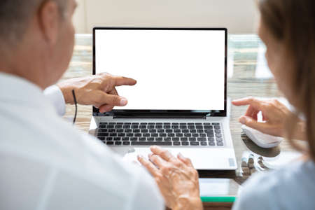 Close-up Of Two Businesspeople Working On Laptop