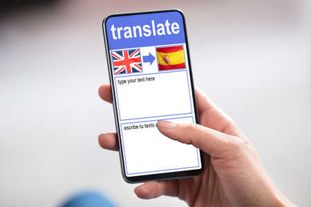 Person Holding Smartphone Showing Language Translate Application With Country Flagの写真素材