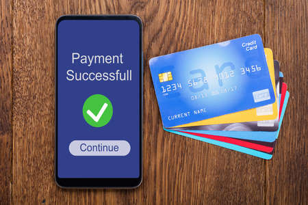 An Elevated View Of Payment Successful Message On Mobilephone Screen With Credit Cardsの写真素材