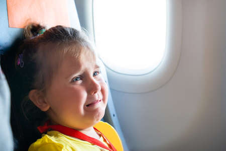 Little Girl Sitting Next To Mother Screaming On Airplane