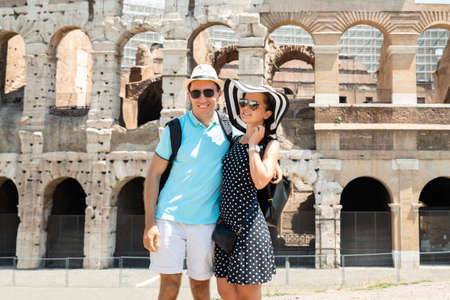 Young Tourist Couple Standing In Front Of Colosseum In Rome, Italyの写真素材