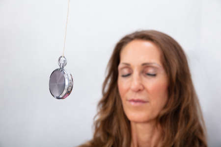 Attractive Mature Woman Being Hypnotized With Pendulum At Home