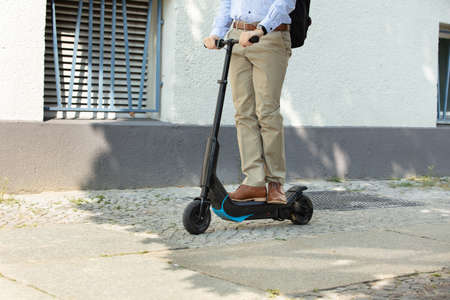 Young Man Riding An Electric Kick Scooter