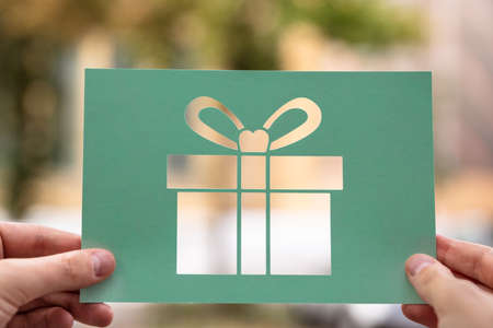 Hands Holding Paper With Cutout Gift Outdoorsの写真素材