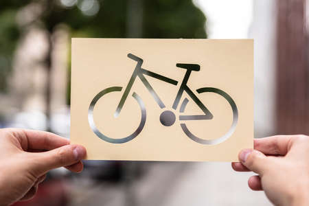 Hands Holding Paper With Cutout Bicycle Outdoorsの写真素材