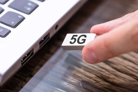 Man Connecting 5G Modem To Laptop Computerの写真素材
