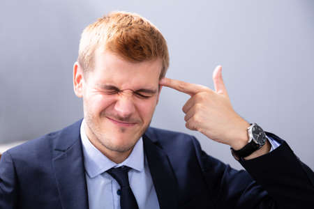 Man Making Shooting Gesture Using His Hand In Officeの写真素材