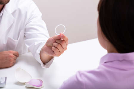 Gynecologist Showing Contraception Ring To Woman And Explaining Contraception And Birth Control Methodsの写真素材